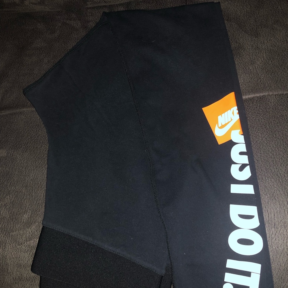 SOLD Women’s Nike Legging size Medium. Black with orange and white details.